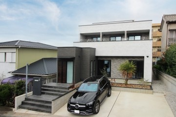 モルタル調のシックな外観を持ち、インテリアでは、珪藻土の塗り壁と木板貼りの堀込天井がおしゃれなLDKのある高級住宅